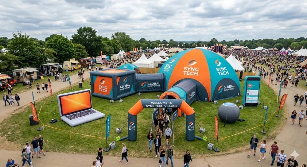 Aerial view of Instent inflatable event structures including a dome and cube tent branded for Sync Tech.